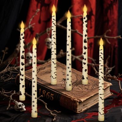 un groupe de bougies posées sur une table, à côté d'un livre