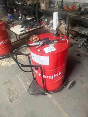 a red barrel sitting on a cart in a garage