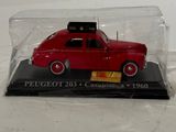 a red toy car in a glass case on a white surface