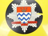 a close up of a badge on the back of a yellow motorcycle