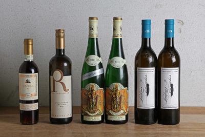 plusieurs bouteilles de vin sont alignées sur une table en bois