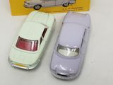 two toy cars sitting next to each other in front of a box