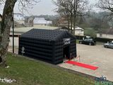 a inflatable tent with a red carpet in a parking lot