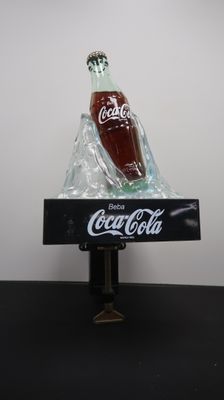 a bottle of coke sitting on top of a black table