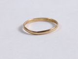gros plan d'une bague en or sur une surface blanche
