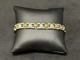 a close up of a gold bracelet on a black pillow