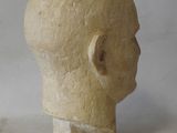 a clay head of a man on a white surface