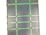 an old book with a checkered pattern on it sitting on a white surface