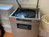 une machine posée sur le sol à côté d'une poubelle