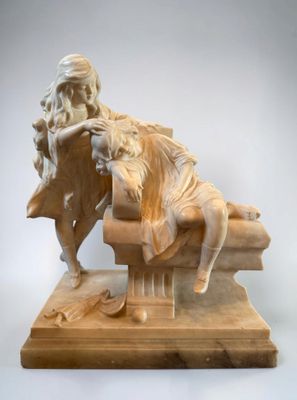 statue of a man sitting on a bench with a book