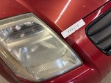 a close up of a car ' s headlight with a sticker on it