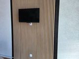 une télévision fixée au mur dans le salon