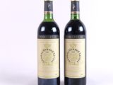 deux bouteilles de vin rouge posées l'une à côté de l'autre sur une surface blanche