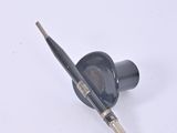 a black brush and a black bottle on a white surface