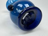 a blue vase with a black handle on a table