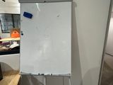 a white board that is on a stand in a room