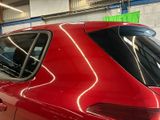 a red car parked in a garage with a green sticker on the back window