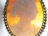 a picture of a woman with a flower in her hair in a broochle