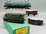 trois petits trains miniatures exposés sur une surface blanche