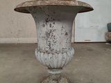 a white vase sitting on top of a cement pedestal
