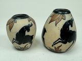 two vases with horses painted on them on a white surface