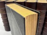 several old books stacked on top of each other on a white surface