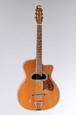 an acoustic guitar hanging from a string on a white background