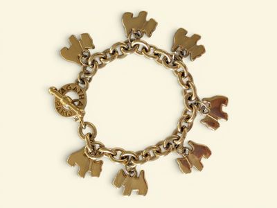 a gold bracelet with charms on it on a white background
