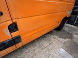 an orange van parked on the side of a road next to a building