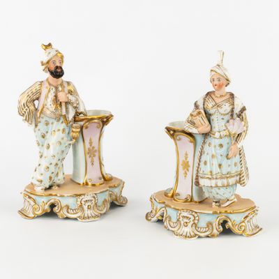pair of porcelain figurines of a man and a woman in blue and gold