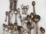 a lot of silver spoons and spoons on the table