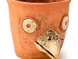 un pot en terre cuite orné d'une tête d'oiseau