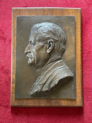 a plaque of a man with a mustache on a red wall