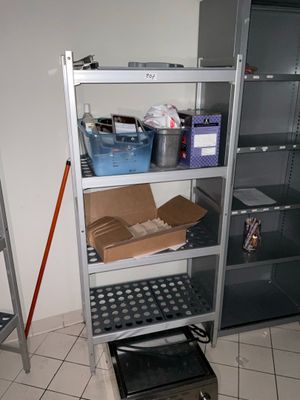 une étagère métallique sur laquelle sont posées des boîtes, dans une pièce