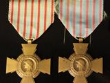 two medals and a pin on a table with pins and pins
