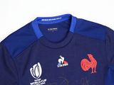 the shirt is blue and has a red rooster on it