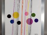 peinture abstraite représentant des cercles multicolores sur fond blanc, dans un cadre argenté