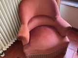 a pink chair in the corner of a living room
