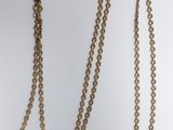 a close up of a gold chain with a heart on it