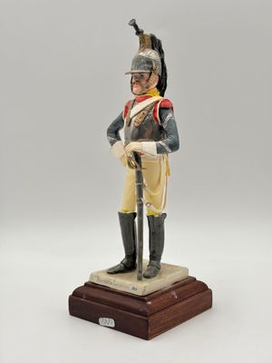 une figurine représentant un soldat muni d'une épée, posée sur un socle en bois