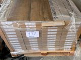 many boxes of wood sitting on a pallet in a warehouse