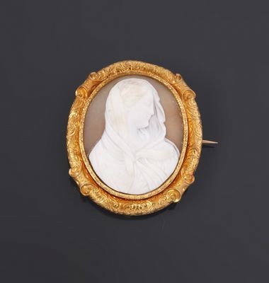 a gold and white cameo of a woman in a veil