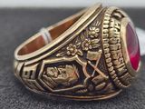 a close up of a gold ring with a red stone on it
