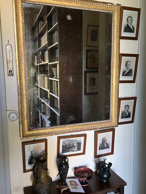 un miroir accroché au mur au-dessus d'une table sur laquelle sont posées des photos