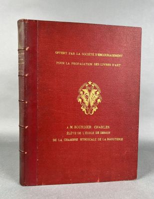 an old red book with a gold emblem on the cover