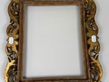 an ornate gold frame with a white background on a wall