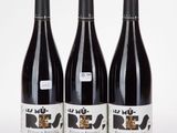 trois bouteilles de vin posées sur une table blanche