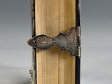 an old book with a metal handle on top of it
