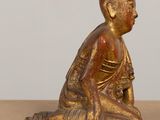 an image of a small statue of a person sitting on the ground