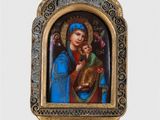 statue de la Vierge à l'Enfant dans un cadre doré orné d'une croix